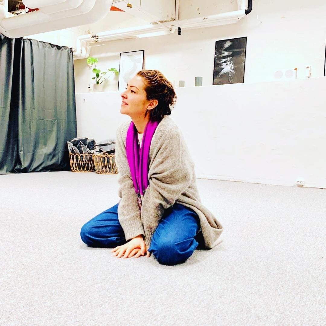 Ashlie Walker sitting on the studio floor watching actors during a class at Actors Academy Finland