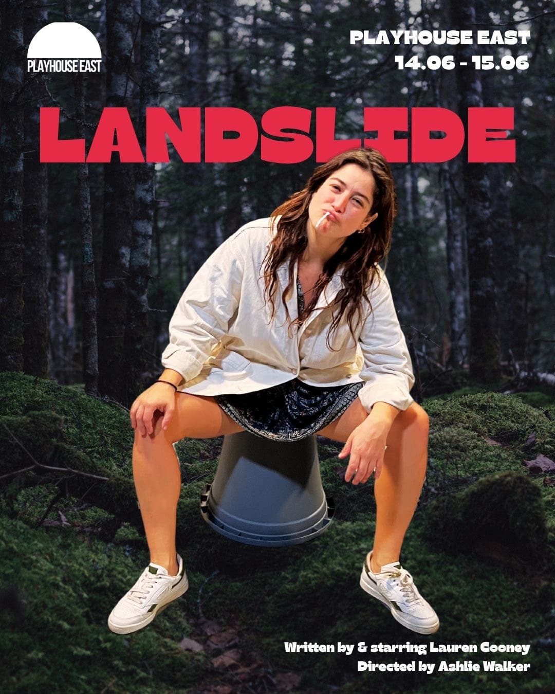 Poster for Landslide at Playhouse East, showing actor Lauren Cooney sitting on an upturned bucket in a forest