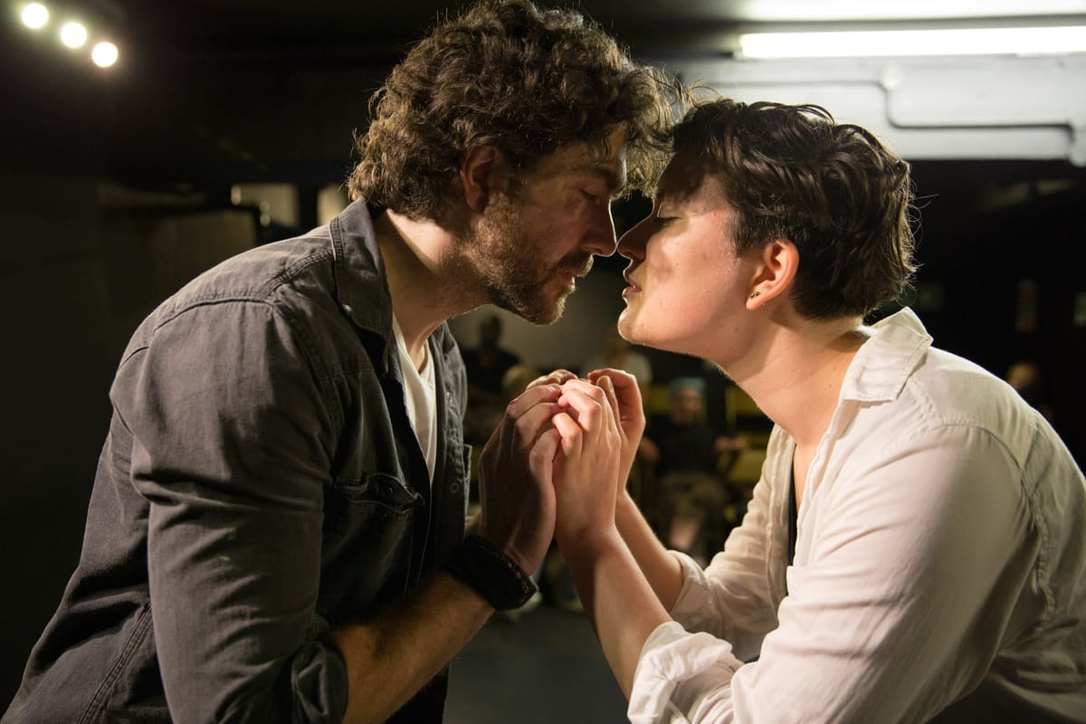 Two actors face to face, holding hands during a scene study